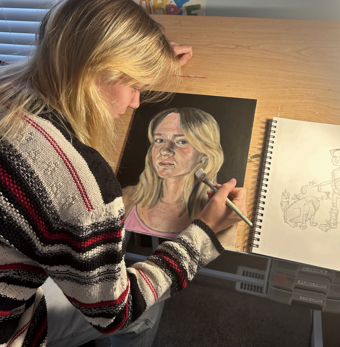 Senior Abby Fitts adds finishing touches to one of her many self-portraits. Fitts uses her self-portraits as outlet for her emotions.